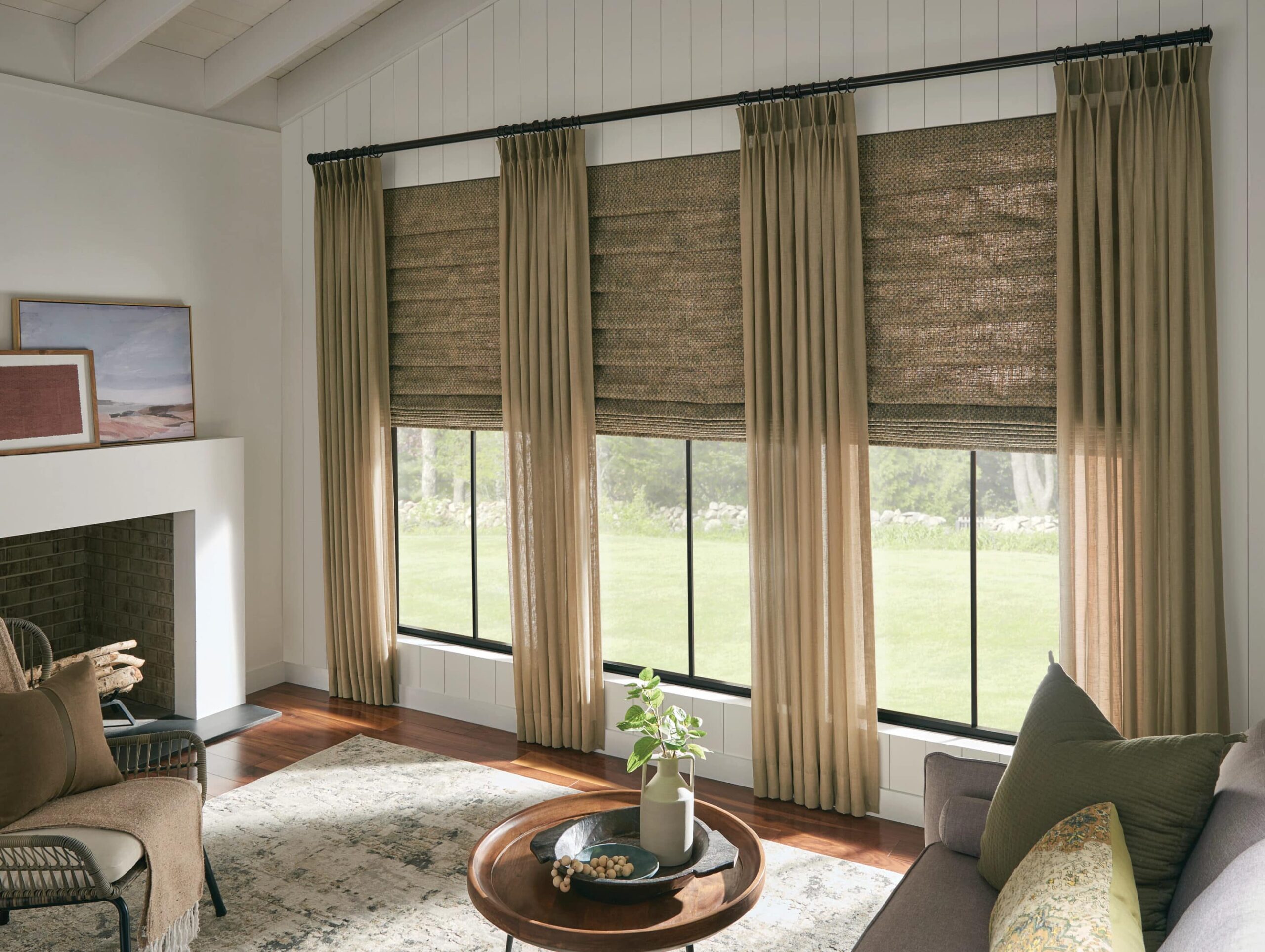 Sheer shades paired with drapery filtering in light into a living room.